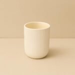 Ivory ribbed ceramic planter with compact round shape and vertical textured finish